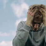 an sitting alone with anxious expression in a calm setting