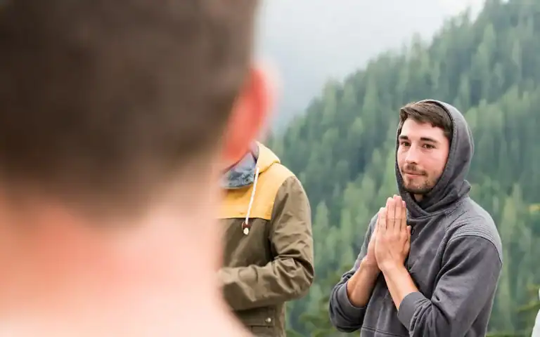 Men standing in a circle outdoors during a men’s work gathering in Nanaimo.